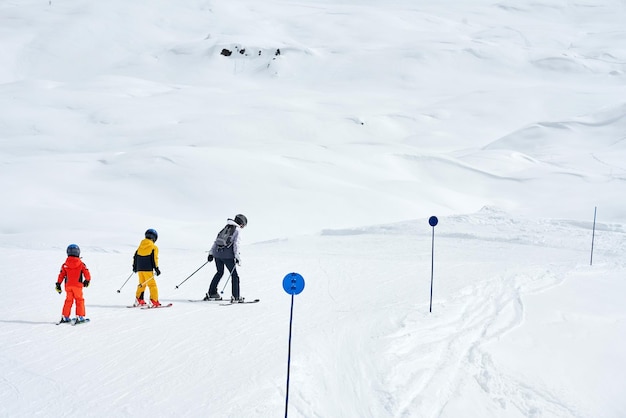 Photo d'une mère qui enseigne le ski à ses enfants à Madonna di Campiglio