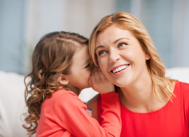 photo d'une mère et sa fille chuchotant des ragots