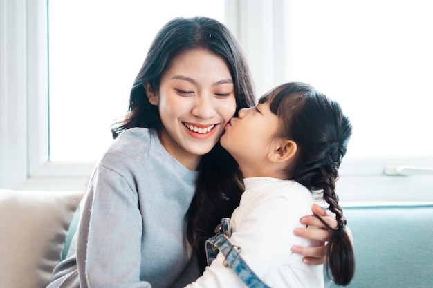 Photo d'une mère et sa fille se câlinant sur le canapé