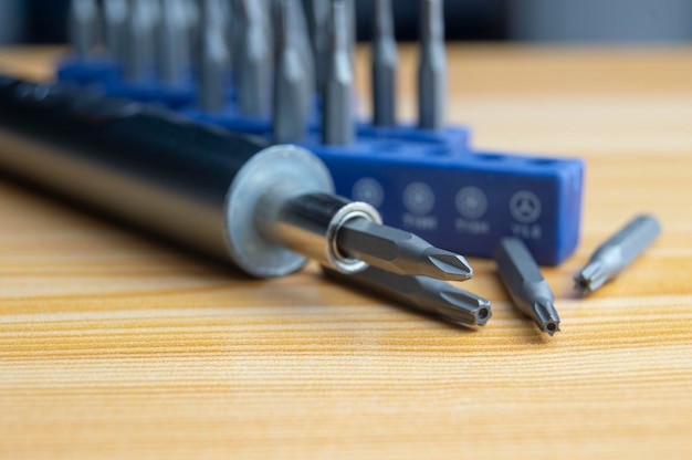 Photo d'un mini tournevis électrique à embout interchangeable posé sur un plancher en bois