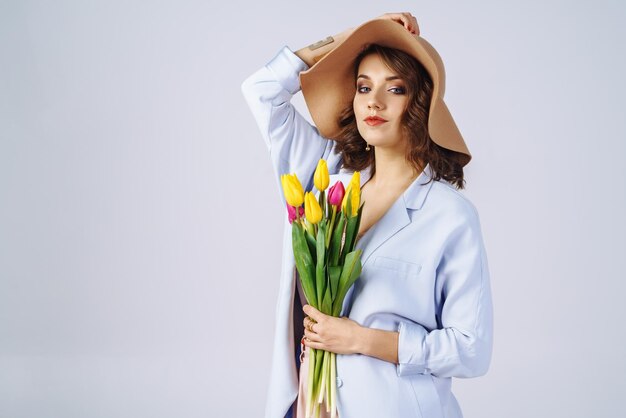 Photo de mode d'une belle femme avec des tulipes dans ses mains Concept de printemps 8 mars