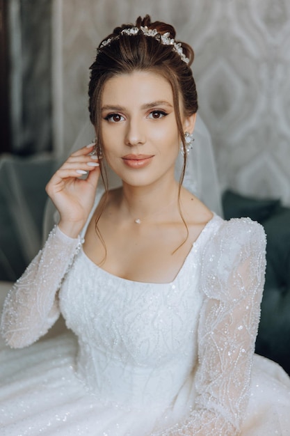 photo de mode d'une belle mariée aux cheveux noirs dans une robe de mariée élégante et un maquillage époustouflant dans la pièce le matin du mariage la mariée se prépare pour le mariage