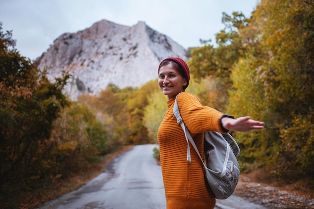 Photo de mode en plein air d'une belle jeune femme entourée d'une forêt d'automne dans les montagnes