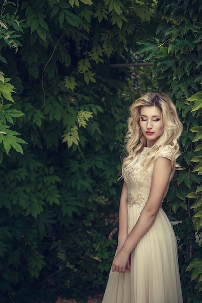 Photo de mode en plein air d'une élégante belle femme aux cheveux blonds en robe de paillettes luxueuse, posant dans le parc d'été