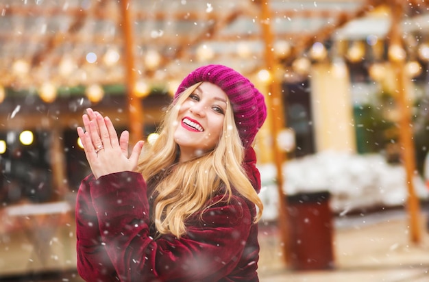 Photo de mode de vie d'une femme joyeuse marchant au marché de rue pendant les chutes de neige. Espace libre