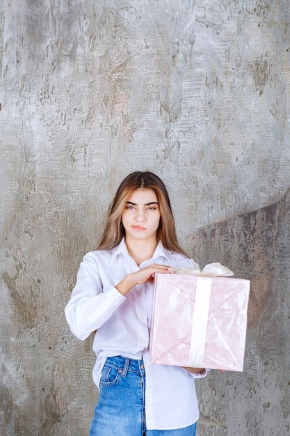 Photo photo d'un modèle de jolie fille aux cheveux longs tenant un grand cadeau