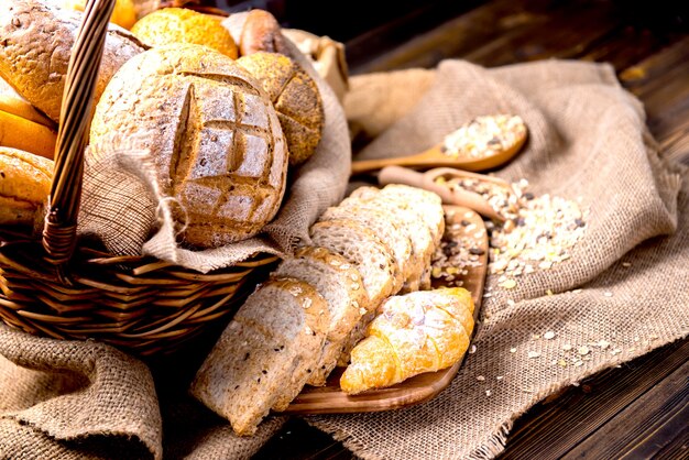 Photo de nature morte de pain et de boulangerie dans le panier en osier. Toasts américains et français pour cuisiner le petit-déjeuner.