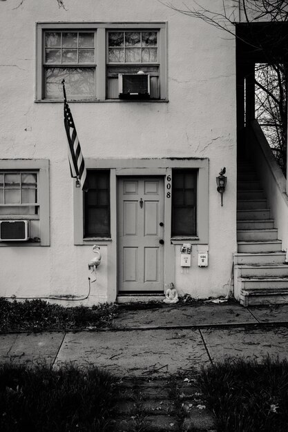 Photo photo en niveaux de gris d'une maison en béton avec une photo du drapeau américain