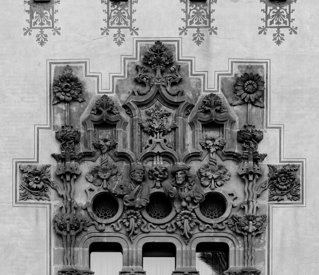 Photo une photo en noir et blanc d'un bâtiment avec une arche décorative au-dessus des fenêtres.