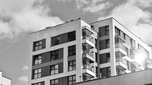 une photo en noir et blanc d'un bâtiment avec un homme sur le toit et un oiseau au sommet.
