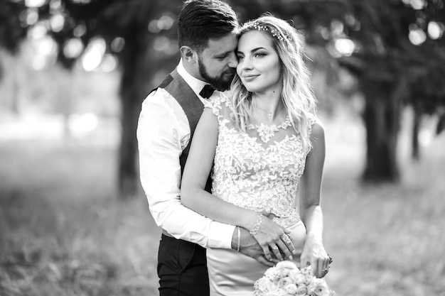 Photo noir et blanc élégant couple de jeunes mariés posant sur un pont le jour du mariage