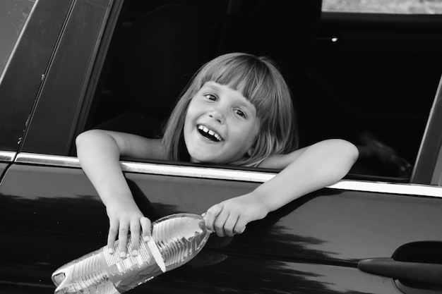 Photo en noir et blanc d'un enfant dans la voiture