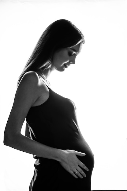 photo noir et blanc d'une femme enceinte sur fond blanc