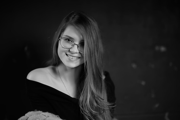 photo en noir et blanc d'une fille à lunettes / lunettes classiques portrait d'une femme d'affaires stricte