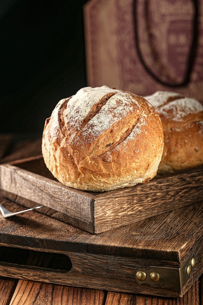 Photo de pain vintage pain de blé cru original deux miches de pain sur un plateau en bois