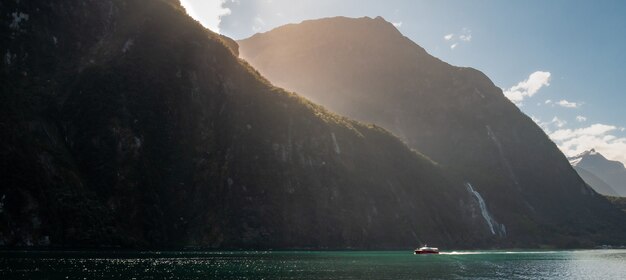 Photo panoramique d'un bateau naviguant dans le fjord par une journée ensoleillée Milford Soundnew Zealand