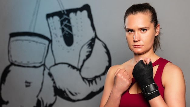 Photo panoramique d'une jeune athlète féminine à l'intérieur de l'entraînement de boxe dans la salle de gym