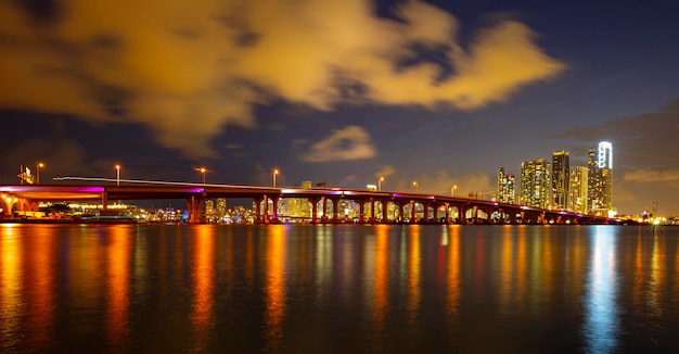 Photo panoramique nocturne du paysage de Miami sur le marché de la baie du centre-ville de Miami derrière Macarthur Causeway