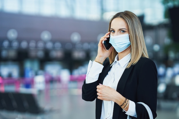 Photo d'une passagère adulte utilisant un smartphone à l'aéroport