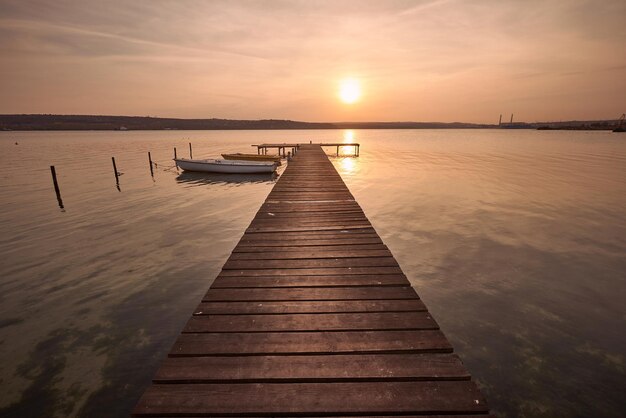 Photo de paysage d'une jetée et de bateaux sur le lac au coucher du soleil à Varna Bulgarie