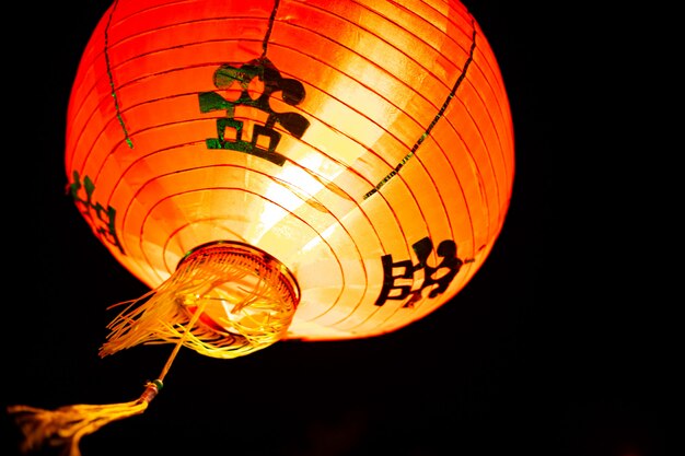 Photo d&#39;une pendaison de lanterne rouge chinoise dans la nuit. Lampe rouge orientale traditionnelle.