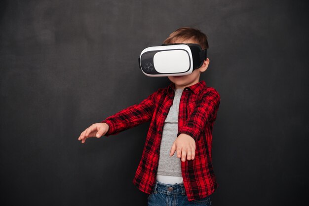 Photo d'un petit enfant portant un appareil de réalité virtuelle sur un tableau noir