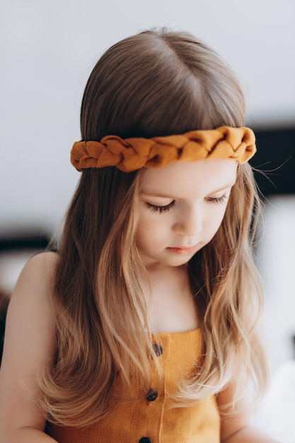 Photo d'une petite fille vêtue de vêtements en lin élégants à la lumière du jour