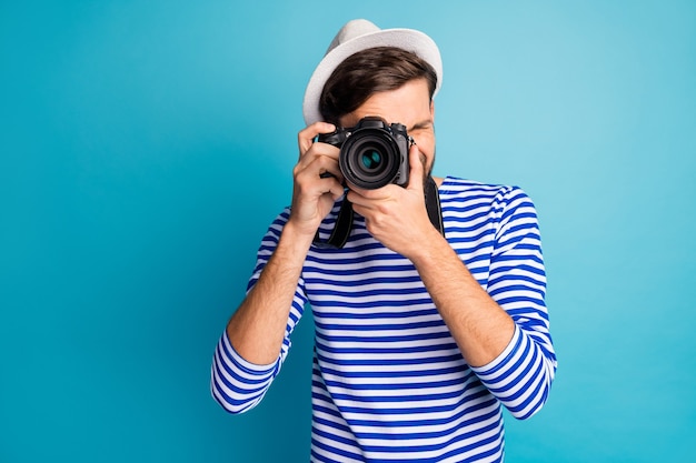 Photo de photographe guy attrayant tenir le voyageur de l'appareil photo à objectif numérique professionnel faire voir des photos porter chemise de marin rayé gilet blanc isolé couleur bleu