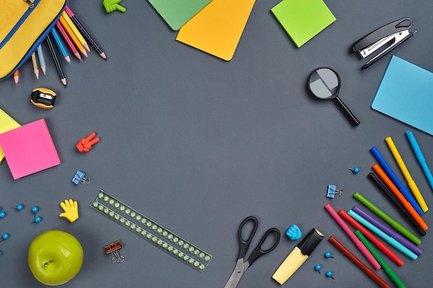 Photo à plat du bureau de l'espace de travail avec des accessoires scolaires ou des fournitures de bureau sur fond gris