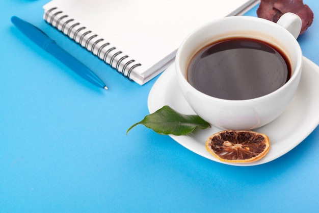 Photo à plat avec ordinateur portable, tasse de café sur fond bleu