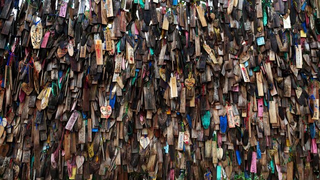 Une photo en plein cadre de parapluies multicolores accrochés au bois