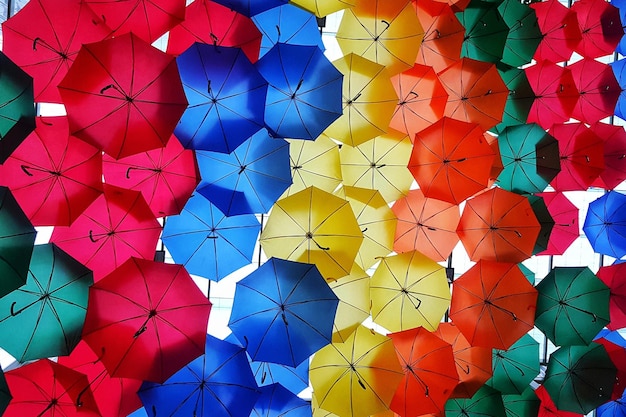 Une photo en plein cadre de parapluies multicolores accrochés au ciel