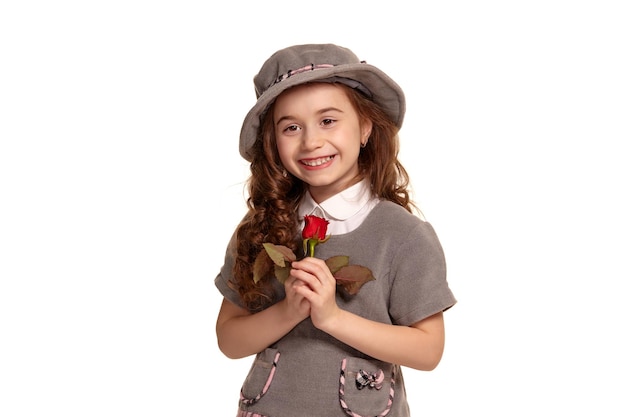 Photo pleine longueur d'un adorable petit enfant aux cheveux longs et bouclés posant isolé sur fond blanc.