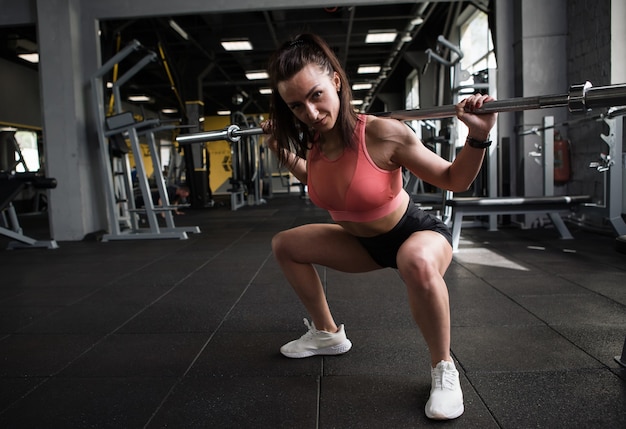 Photo pleine longueur d'une femme de remise en forme faisant des squats avec haltères, espace pour copie