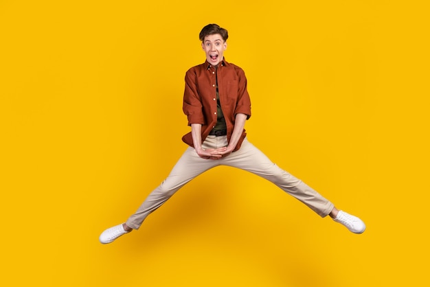 Photo pleine longueur d'un jeune homme joyeux s'amuser sauter le week-end de printemps isolé sur fond de couleur jaune