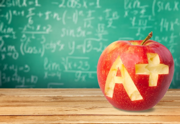 Photo de pomme rouge avec A+ sur le banc de l'école