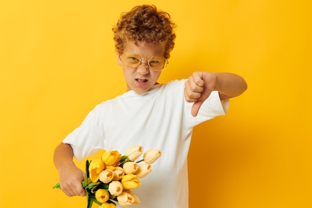 Photo portrait curly petit garçon avec des fleurs jaunes posant enfance amusant fond isolé inchangé