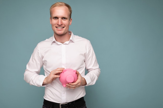 Photo de portrait d'un jeune bel homme blond souriant et positif avec des émotions sincères portant