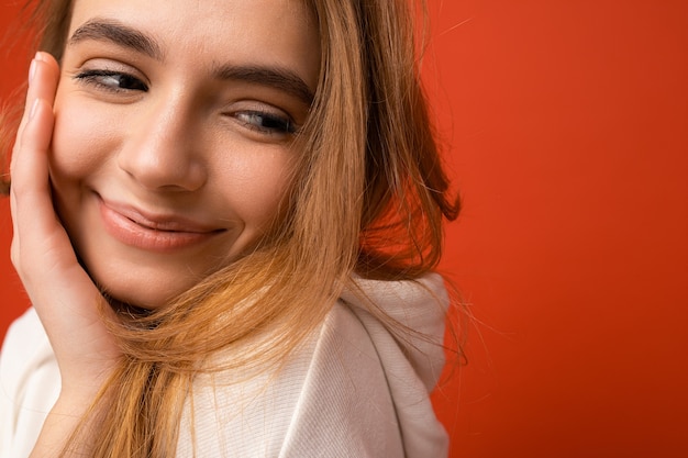 Photo de portrait de jeune femme blonde foncée attrayante avec des émotions sincères isolées sur