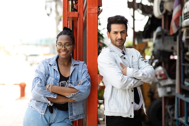 Photo de portrait de modélisation. Employée afro-américaine et gestionnaire d'homme hispanique travaillant ensemble dans un ancien magasin d'entrepôt de pièces automobiles et automobiles.