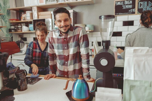 Photo positive d'un barista masculin debout derrière un comptoir