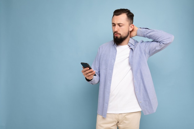 Photo prise de vue d'un beau jeune homme bien réfléchi positif portant une tenue élégante décontractée