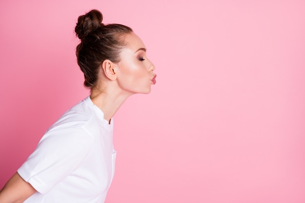 Photo de profil de charmante dame coiffure drôle envoyant des baisers aériens côté espace vide coquette