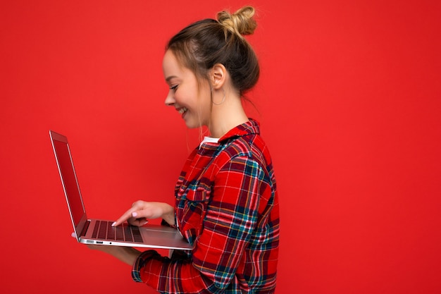 Photo de profil côté gros plan de jeune femme souriante tenant netbook