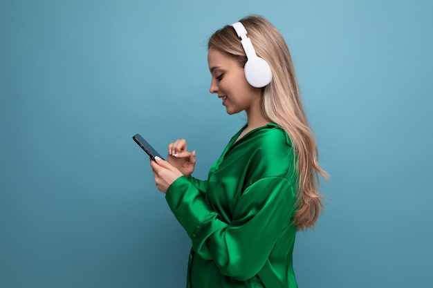 Photo de profil d'une jolie jeune femme adulte blonde dans un casque sur fond bleu