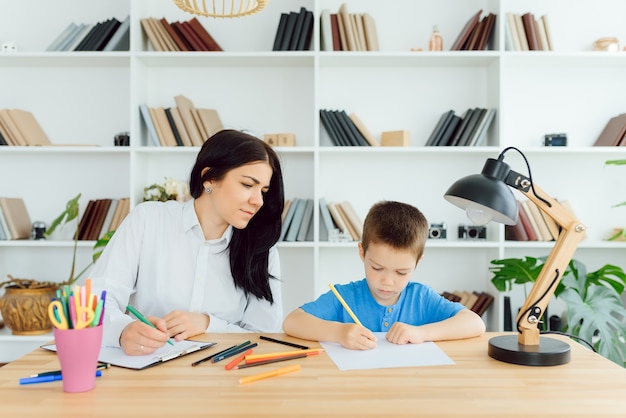 Photo de psychologue pour enfants travaillant avec un jeune garçon au bureau