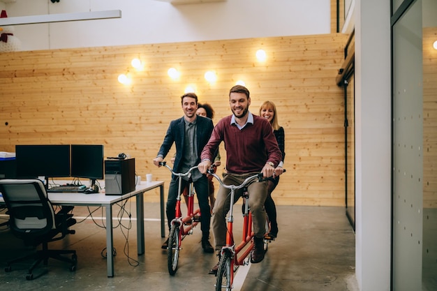 Photo de quatre collègues faisant du vélo tandem sur leur lieu de travail