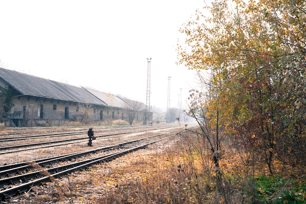 Photo de rails abandonnés et d'une gare