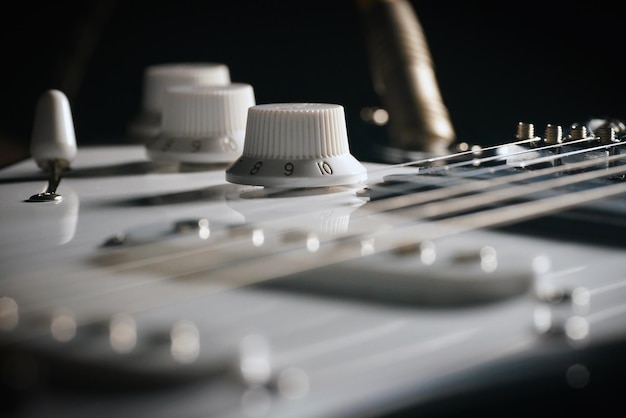 Photo une photo rapprochée d'une guitare électrique noire sur un fond noir