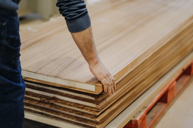 Une photo rapprochée d'un ouvrier tenant des planches de stratifié